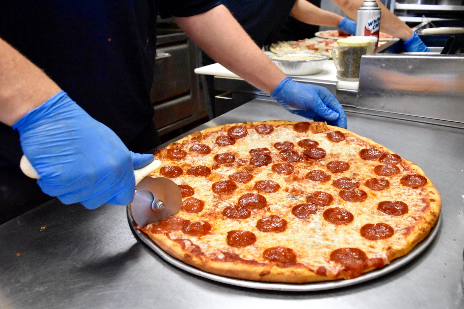 Photo of man cutting a pizza